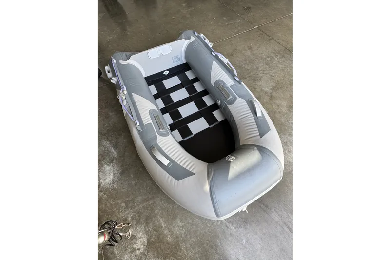 Slide: The Image of Inflatable gray dinghy on concrete floor, featuring a checkered interior design. - 51