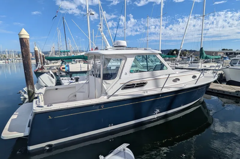 Slide: The Image of 2008 Back Cove 29 boat docked in a marina, surrounded by sailboats. - 9