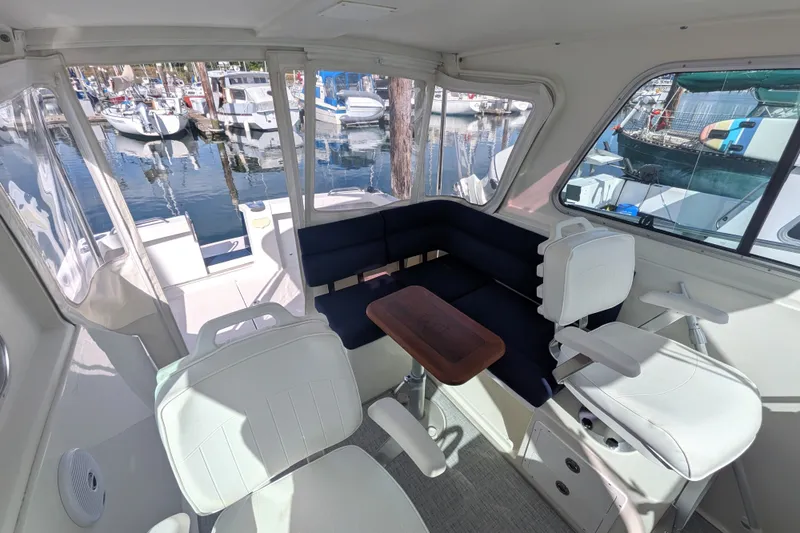 Slide: The Image of Interior of 2008 Back Cove 29 boat with seating and marina view. - 18
