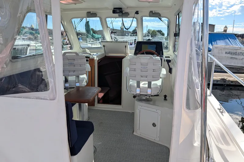 Slide: The Image of Interior view of a 2008 Back Cove 29 boat, featuring helm and seating area. - 12