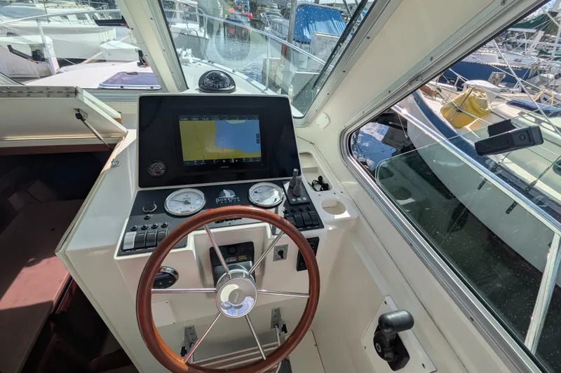 Slide: The Image of 2008 Back Cove 29 boat helm with navigation display and steering wheel. - 19