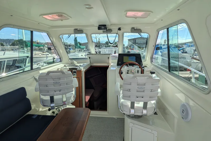 Slide: The Image of Interior view of a 2008 Back Cove 29 boat, featuring helm and seating area. - 16