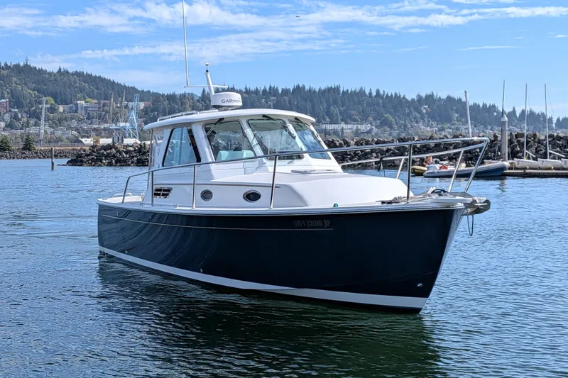 Slide: The Image of 2008 Back Cove 29 boat cruising in a scenic harbor setting. - 2