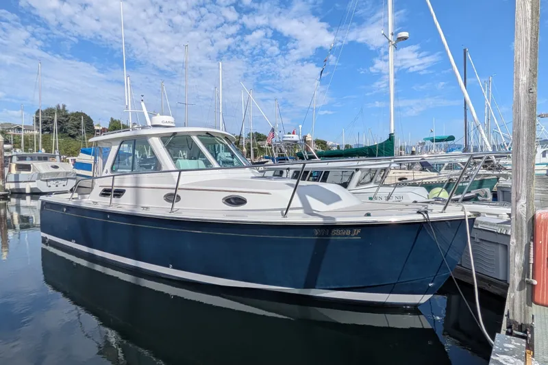 Slide: The Image of 2008 Back Cove 29 boat docked in marina, blue hull, clear sky background. - 7