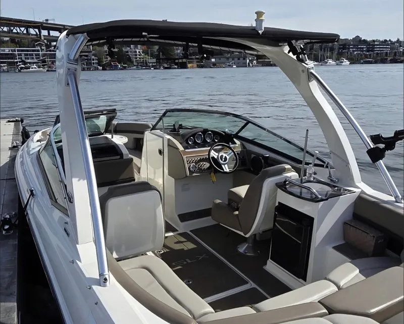 Slide: The Image of A 2012 Sea Ray SLX 250 docked. It features a sleek design with an open cockpit and modern helm. - 2