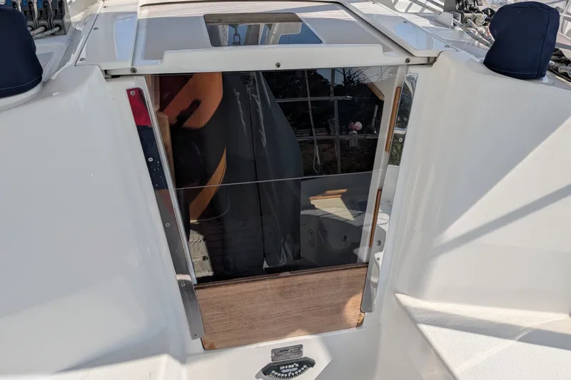 Slide: The Image of Cabin entrance of a 2003 Catalina 350 sailboat with reflective glass and wooden trim. - 18