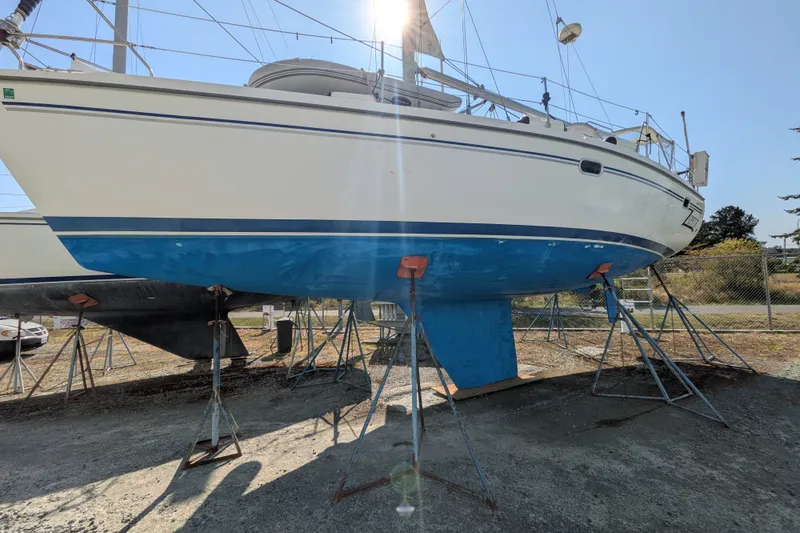 Slide: The Image of 2003 Catalina 350 sailboat on stands, hull painted blue, in a boatyard. - 42