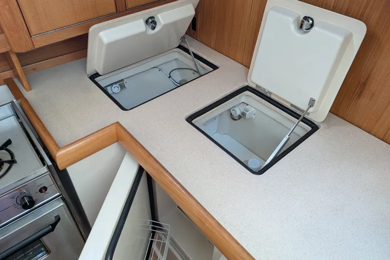 Slide: The Image of Interior of a 2003 Catalina 350 yacht kitchen with open storage compartments. - 24