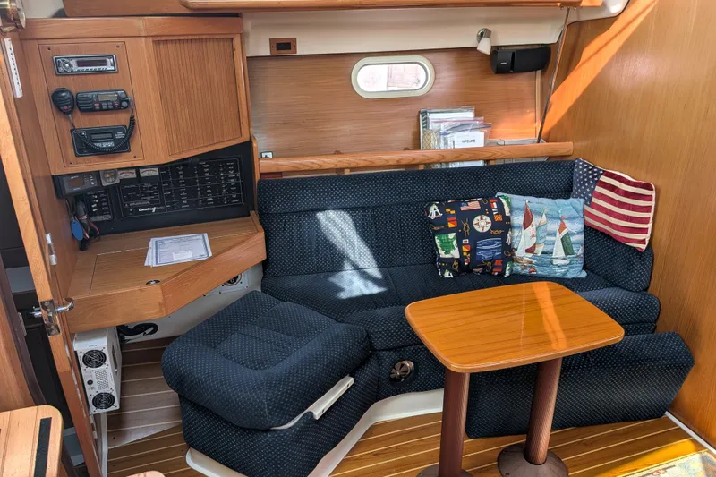 Slide: The Image of Interior of a 2003 Catalina 350 sailboat with cozy seating and nautical-themed decor. - 22