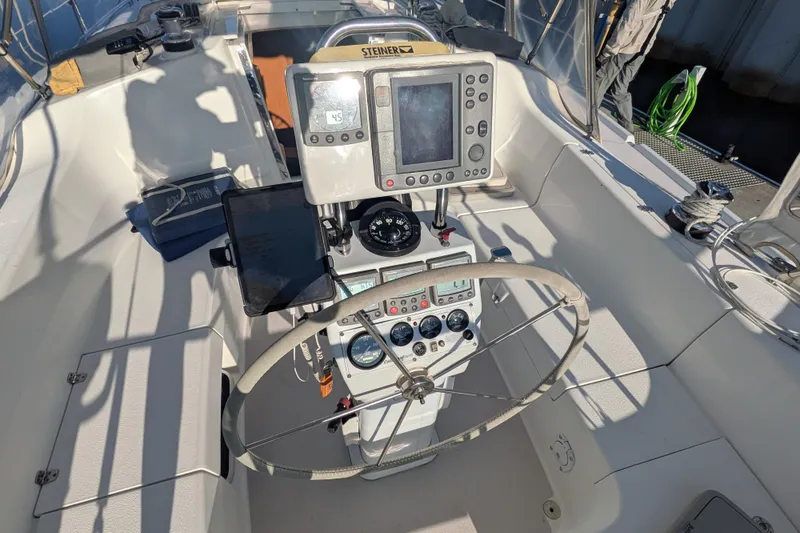 Slide: The Image of Cockpit of a 2003 Catalina 350 sailboat with navigation equipment and steering wheel. - 13
