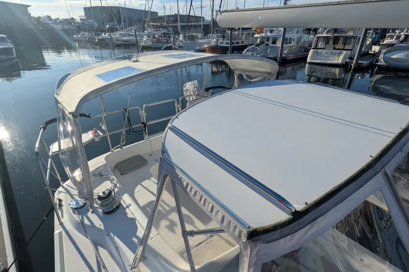 Slide: The Image of 2003 Catalina 350 sailboat docked in a marina, featuring a spacious deck and canopy. - 9