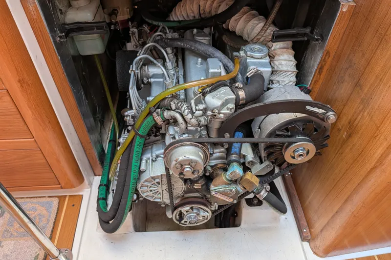 Slide: The Image of Engine compartment of a 2003 Catalina 350 sailboat, showcasing mechanical components and hoses. - 38