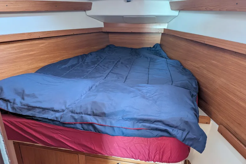 Slide: The Image of Cozy cabin bed in a 2003 Catalina 350 sailboat with wooden paneling. - 35