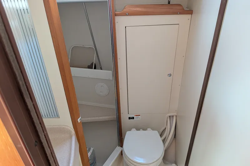 Slide: The Image of 2003 Catalina 350 yacht bathroom with compact toilet and storage cabinet. - 36