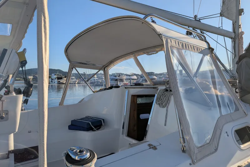 Slide: The Image of 2003 Catalina 350 sailboat cockpit with marina view, featuring clear canopy and nautical equipment. - 10