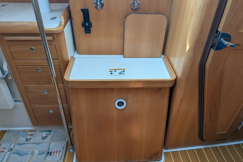 Slide: The Image of Interior of a 2003 Catalina 350 sailboat featuring wooden cabinetry and a compact sink area. - 39