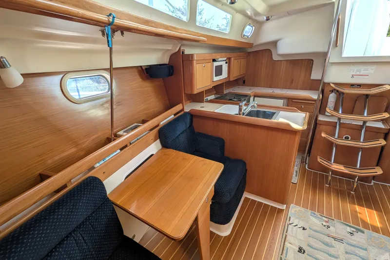 Slide: The Image of Interior of a 2003 Catalina 350 sailboat featuring a cozy kitchen and dining area. - 27