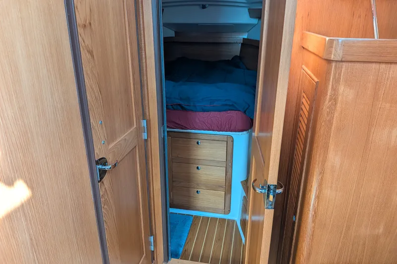 Slide: The Image of Interior cabin of a 2003 Catalina 350 sailboat with wooden finish and cozy bedding. - 34