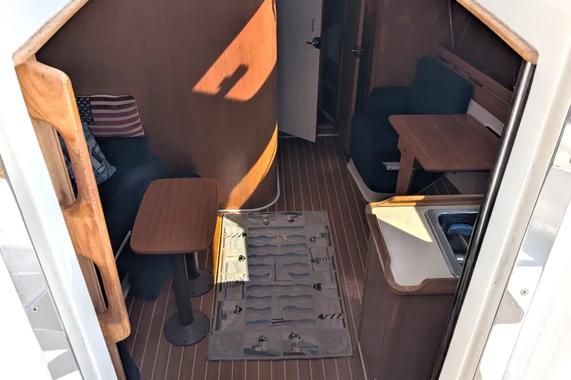 Slide: The Image of Interior of a 2003 Catalina 350 sailboat featuring cozy seating and a compact kitchenette. - 19