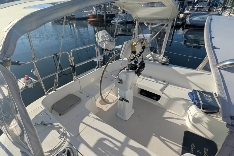 Slide: The Image of 2003 Catalina 350 sailboat cockpit with steering wheel, docked in a marina. - 12