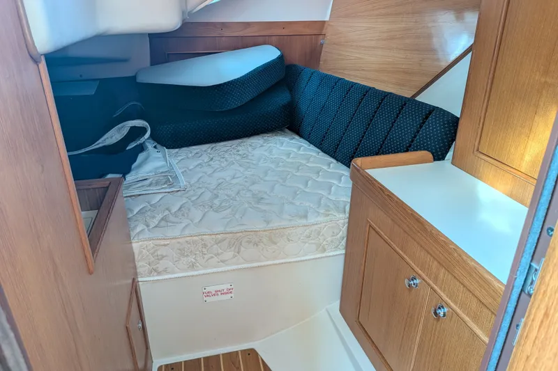 Slide: The Image of Cozy cabin interior of a 2003 Catalina 350 sailboat with a comfortable bed and wooden cabinetry. - 32