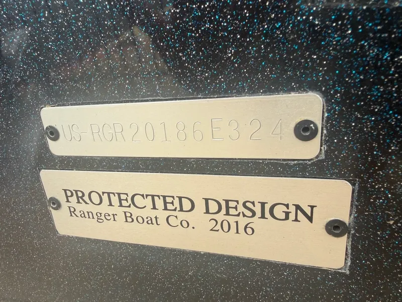 Slide: The Image of Close-up of two metal plaques on a boat hull. One shows a serial number, the other "Protected Design." - 26