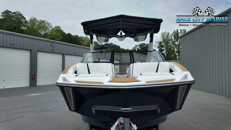 Slide: The Image of A modern Nautique P23 boat from 2027 is parked in front of garages. - 3