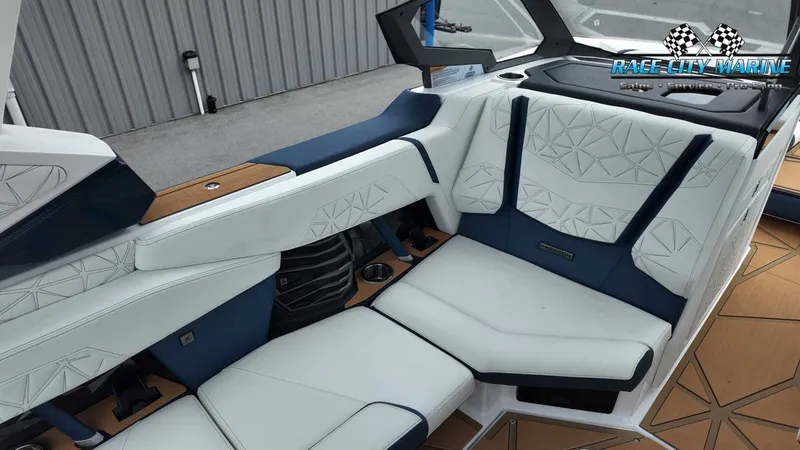 Slide: The Image of The image shows the luxurious interior of a Nautique P23 boat with white and blue upholstery. - 34