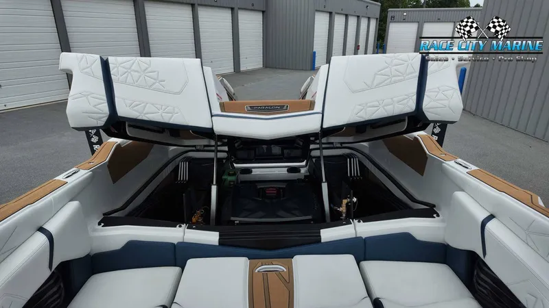 Slide: The Image of The image shows the interior of a 2027 Nautique P23 boat with white and blue seating. - 23