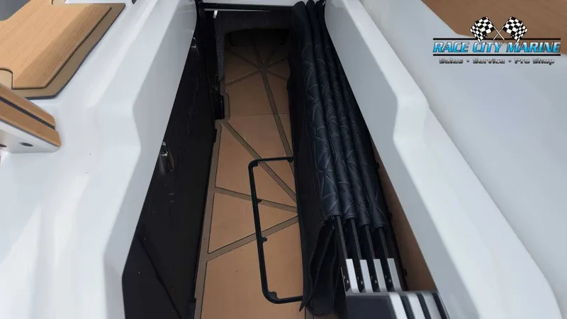 Slide: The Image of View of a 2027 Nautique P23 boat interior with stacked paddles. - 16