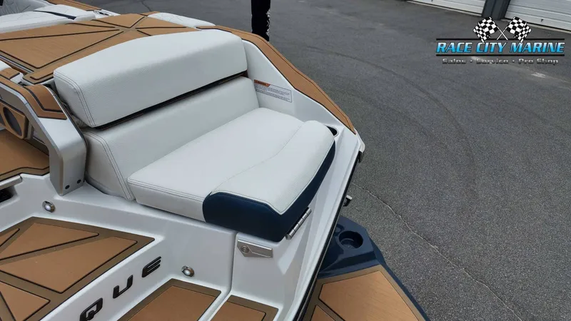 Slide: The Image of The image shows the stern of a Nautique P23 boat with white and blue upholstery. - 15