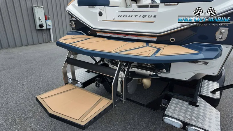 Slide: The Image of The image shows the rear of a 2027 Nautique P23 boat with a fold-out swim platform. - 9