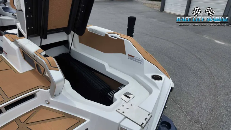Slide: The Image of The image shows the stern of a 2027 Nautique P23 boat with storage and brown accents. - 12