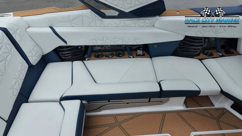 Slide: The Image of The image shows the luxurious interior of a 2027 Nautique P23 boat with white and blue upholstery. - 25