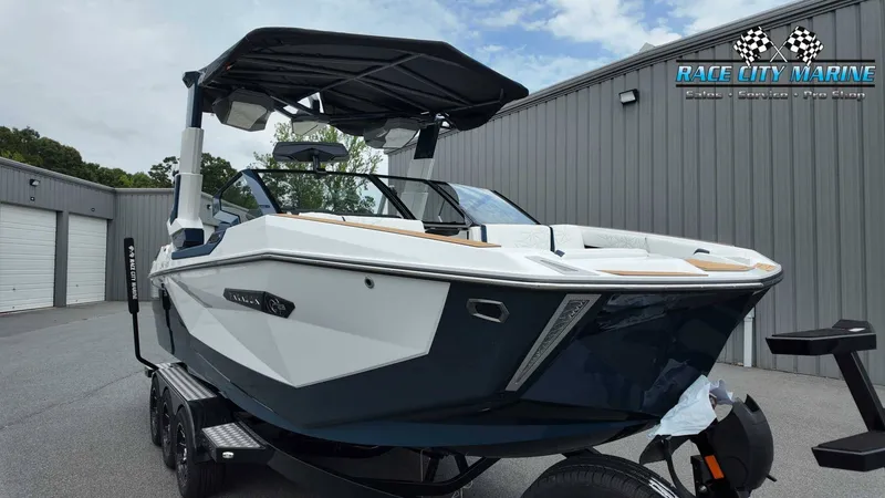 Slide: The Image of A modern 2027 Nautique P23 sits on a trailer in front of a gray building. - 5