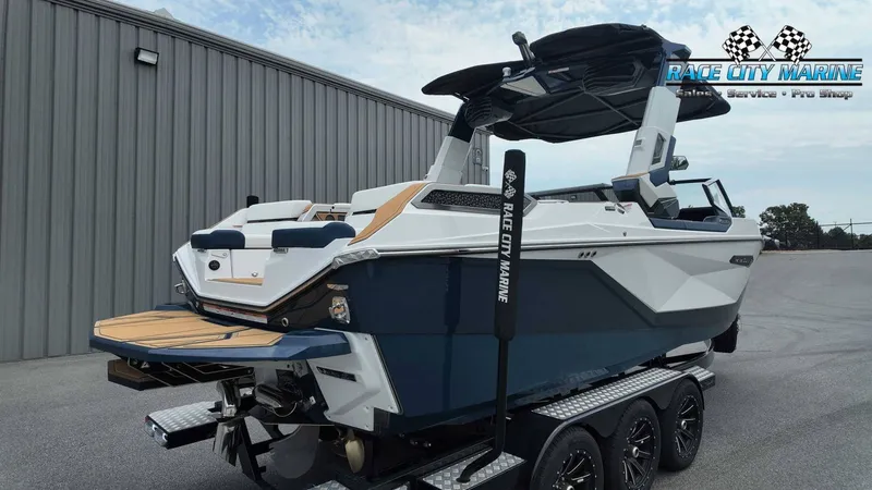 Slide: The Image of A modern Nautique P23 boat from 2027 sits on a trailer in front of a building. - 8
