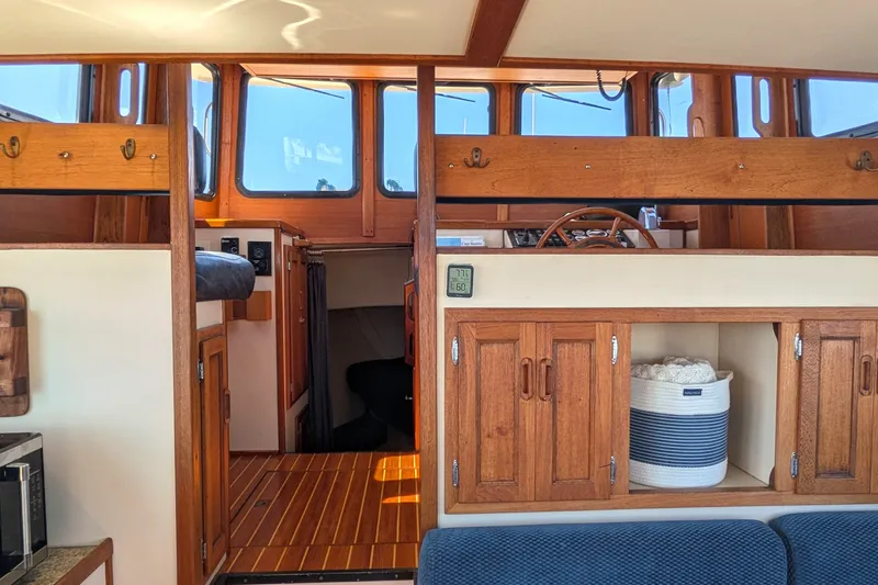 Slide: The Image of Interior of a 1997 Nordic Tug 32, featuring wooden cabinetry and helm station. - 27