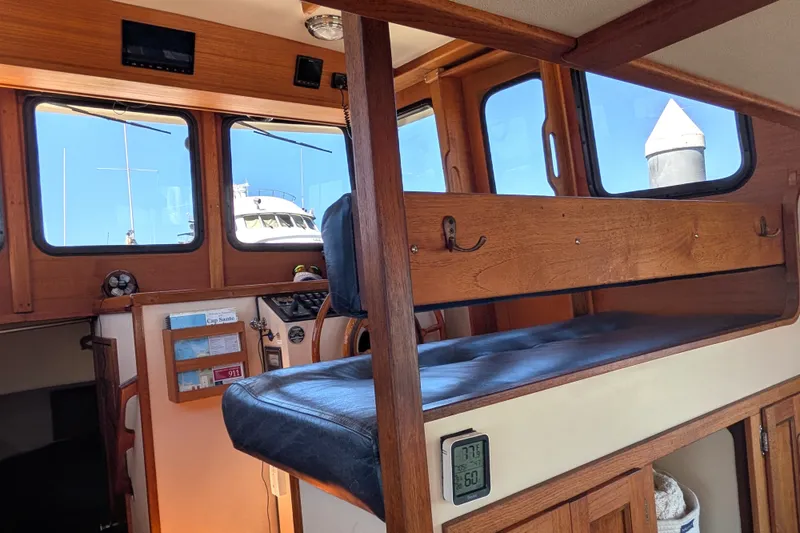 Slide: The Image of Interior of a 1997 Nordic Tug 32 boat with wooden accents and seating. - 28