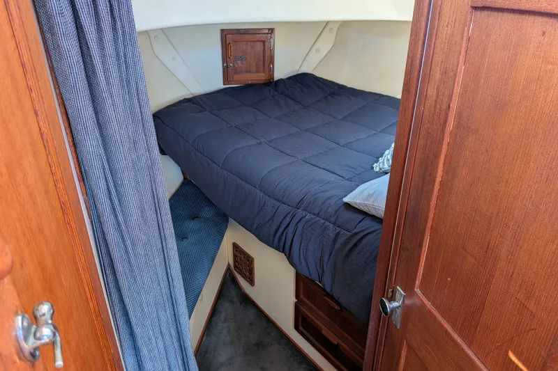 Slide: The Image of Cozy cabin interior of a 1997 Nordic Tug 32 with a comfortable bed and wooden accents. - 39