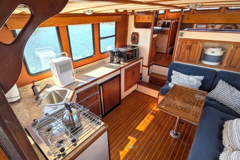 Slide: The Image of Interior of a 1997 Nordic Tug 32, featuring a cozy kitchen and seating area. - 17