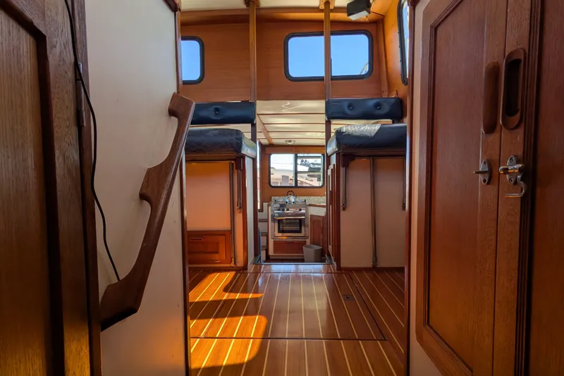 Slide: The Image of Interior of a 1997 Nordic Tug 32, featuring wood paneling and compact kitchen. - 43