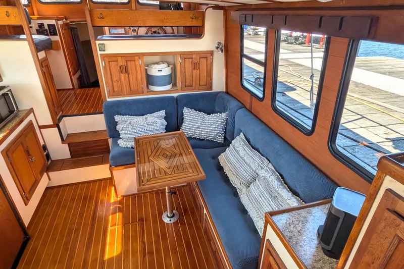 Slide: The Image of Cozy interior of a 1997 Nordic Tug 32 with wooden accents and blue seating. - 18