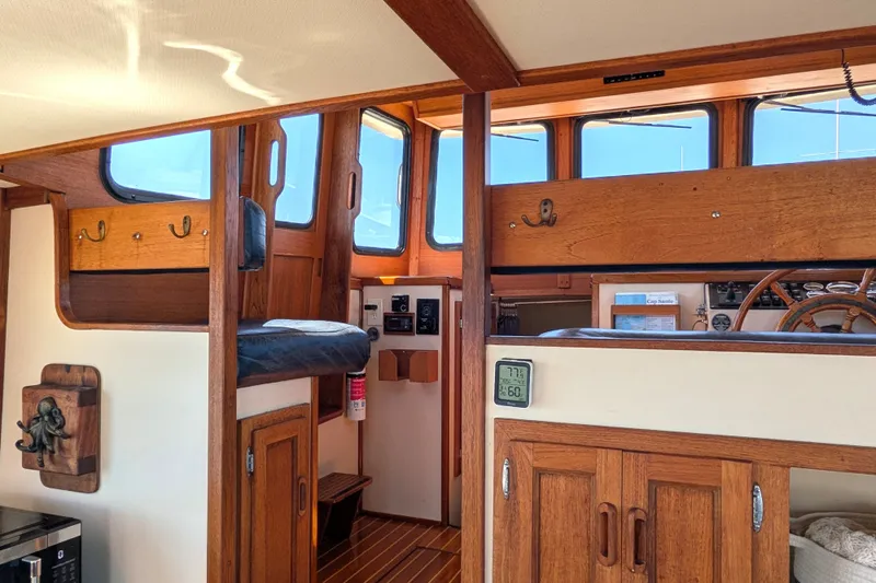 Slide: The Image of Interior of a 1997 Nordic Tug 32, featuring wooden cabinetry and helm station. - 29