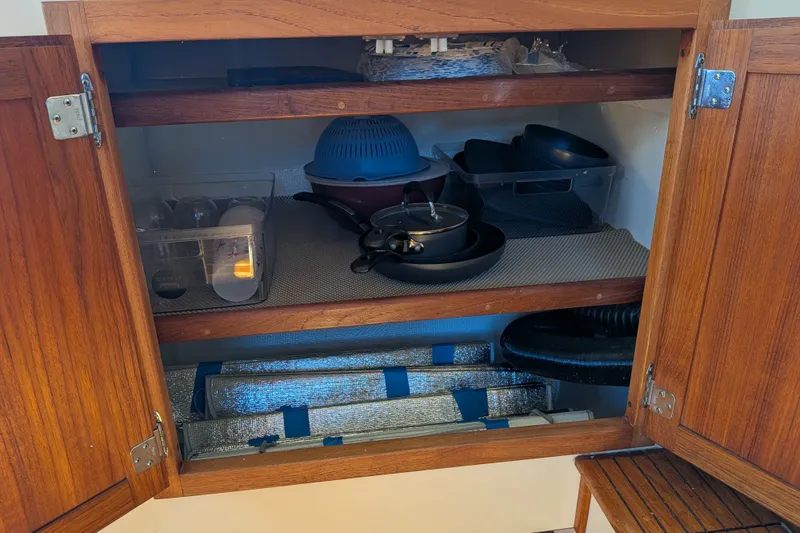 Slide: The Image of Wooden cabinet in a 1997 Nordic Tug 32, storing kitchenware and cookware. - 25