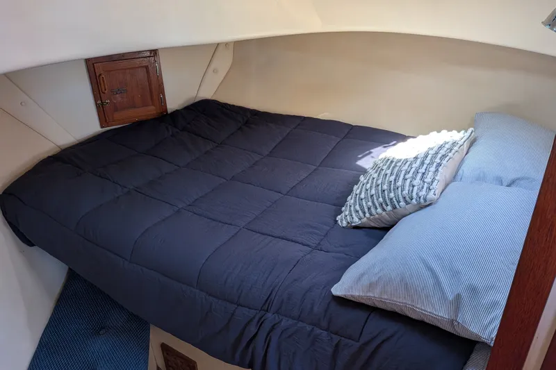 Slide: The Image of Cozy cabin bed in 1997 Nordic Tug 32 with dark bedding and decorative pillows. - 40