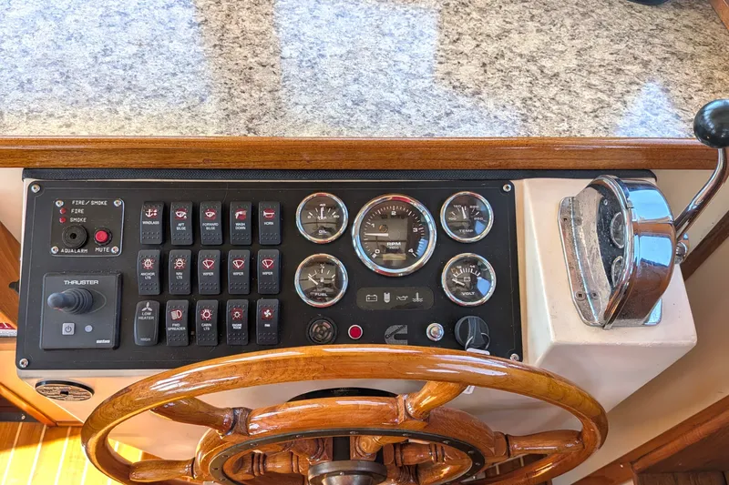 Slide: The Image of Helm of 1997 Nordic Tug 32 with gauges, switches, and wooden steering wheel. - 31