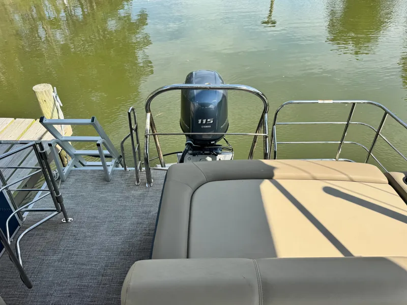 Slide: The Image of The image shows the stern of a pontoon boat with a 115 HP outboard motor, docked at a pier. - 7