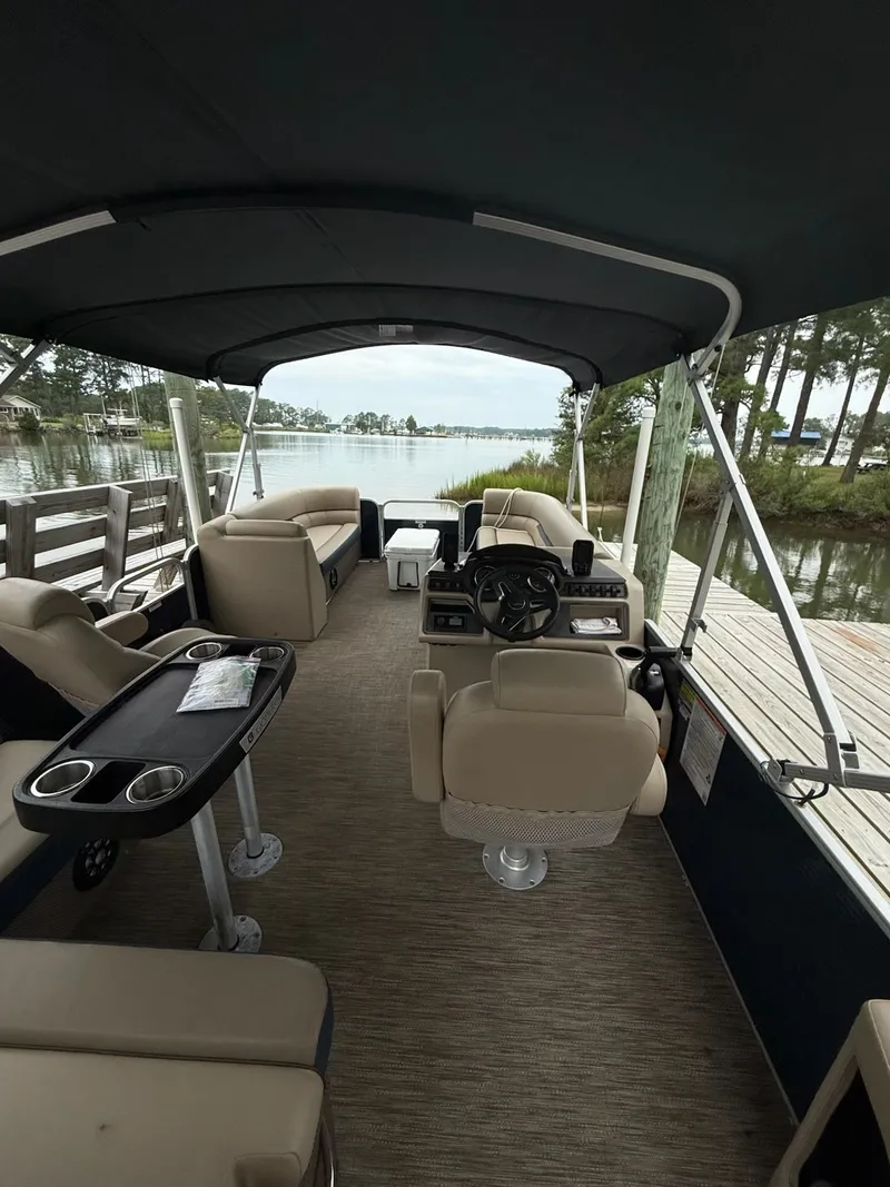 Slide: The Image of Interior view of a Godfrey Sweetwater 2286 SFL pontoon boat with beige seating and a black canopy. - 8