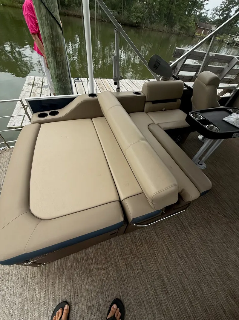Slide: The Image of The image shows a beige lounging area on a boat, surrounded by water and a dock. - 16