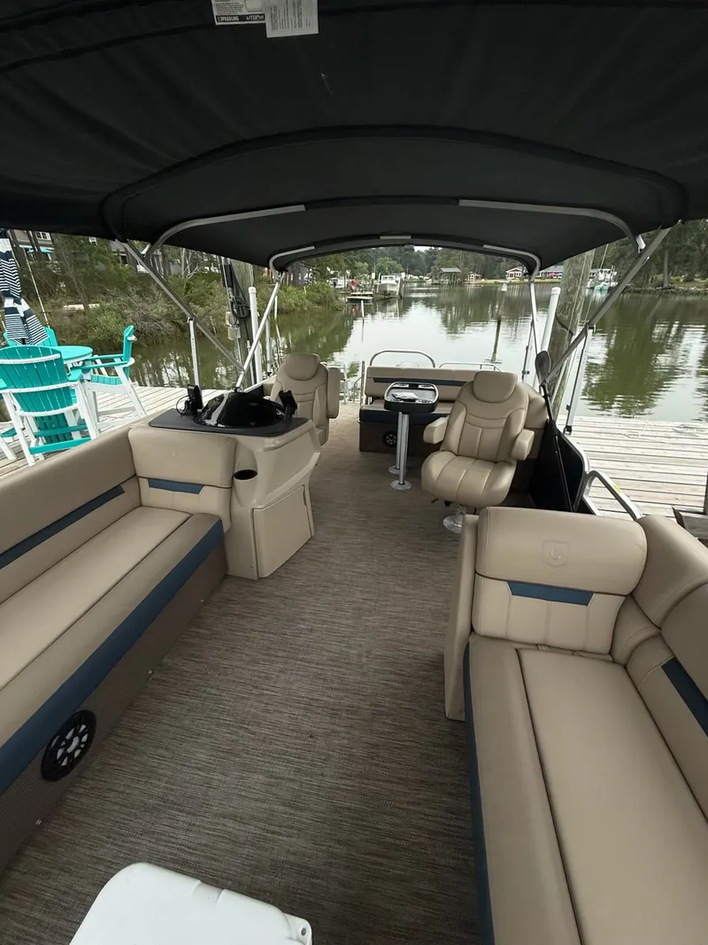 Slide: The Image of The image shows the interior of a 2022 Godfrey Sweetwater 2286 SFL pontoon boat with beige seating and a black canopy. - 17